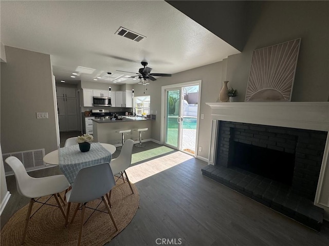 38422 Puma Ln, Palmdale, CA 93551 - dining space featuring wood finished floors, baseboards, a ceiling fan, and a fireplace