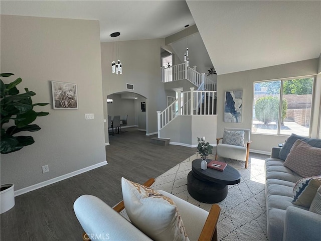 38422 Puma Ln, Palmdale, CA 93551 - living room featuring arched walkways, stairs, wood finished floors, baseboards, and high vaulted ceiling