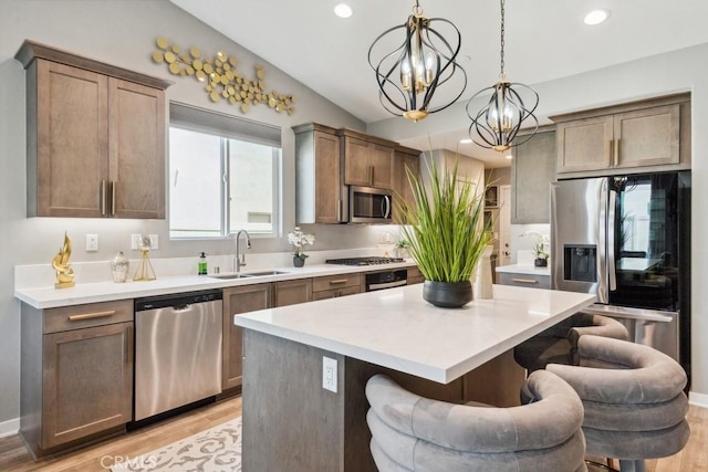 29589 Woodcreek Trl, Winchester, CA 92596 - kitchen with appliances with stainless steel finishes, a sink, a chandelier, a breakfast bar, and light wood-style floors