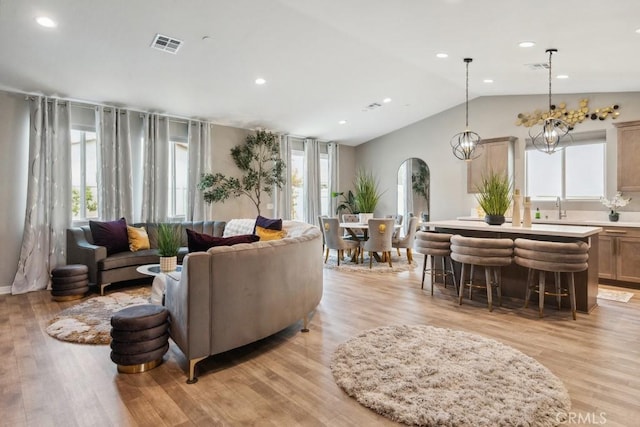 29589 Woodcreek Trl, Winchester, CA 92596 - living room featuring lofted ceiling, arched walkways, light wood-type flooring, and recessed lighting