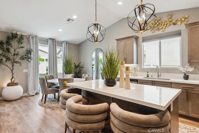 29589 Woodcreek Trl, Winchester, CA 92596 - kitchen with a chandelier, a sink, lofted ceiling, light countertops, and a breakfast bar