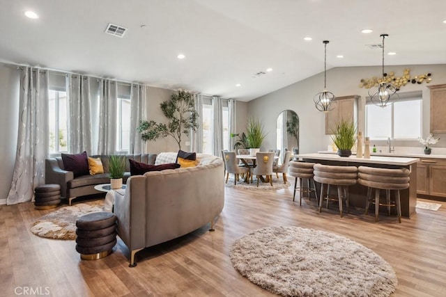 29589 Woodcreek Trl, Winchester, CA 92596 - living room featuring arched walkways, light wood-type flooring, vaulted ceiling, and recessed lighting