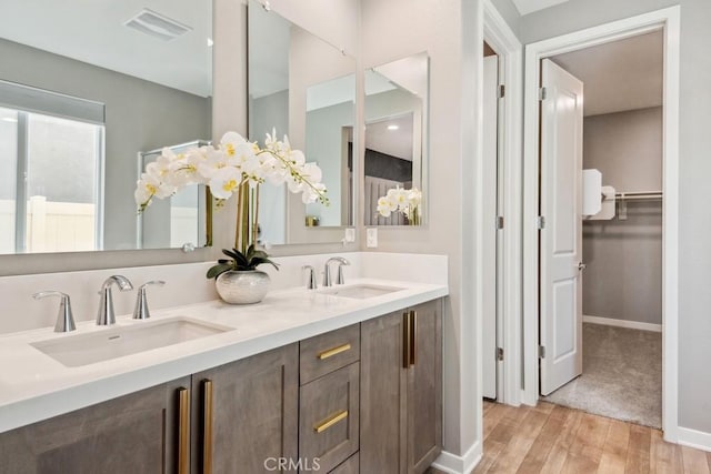 29589 Woodcreek Trl, Winchester, CA 92596 - bathroom featuring double vanity, wood finished floors, and baseboards