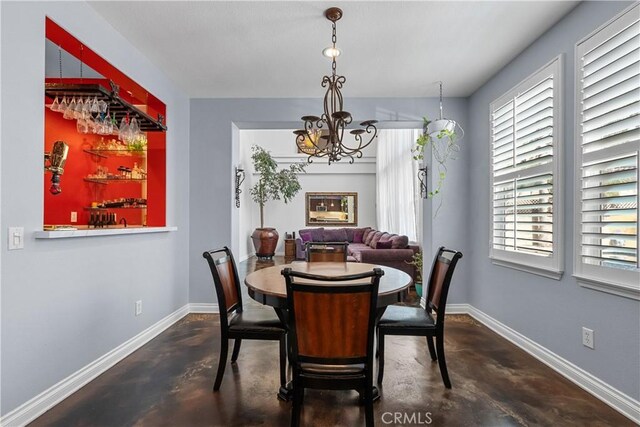 29259 Black Pine Way, Saugus, CA 91390 - dining room featuring concrete flooring, a chandelier, baseboards, and a bar