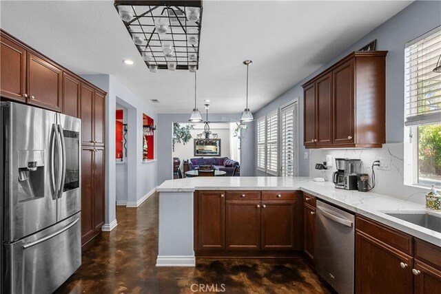 29259 Black Pine Way, Saugus, CA 91390 - kitchen featuring appliances with stainless steel finishes, a peninsula, concrete floors, baseboards, and decorative backsplash