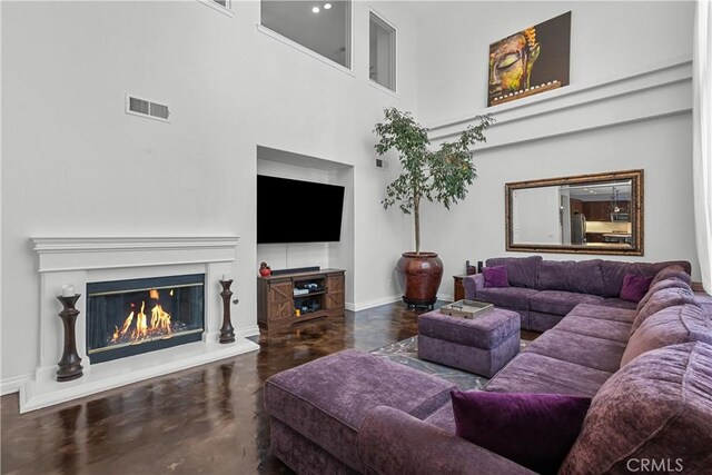 29259 Black Pine Way, Saugus, CA 91390 - living room featuring baseboards, concrete floors, a high ceiling, and a glass covered fireplace