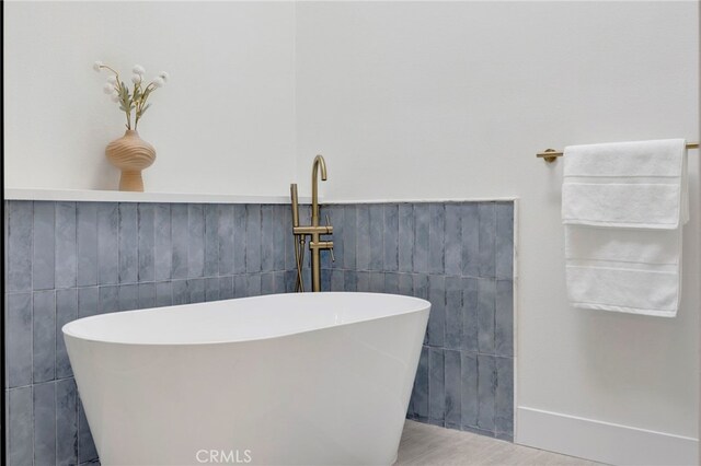 23043 Park Este, Calabasas, CA 91302 - bathroom with a freestanding tub, tile walls, a wainscoted wall, and wood finished floors