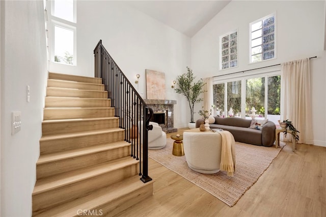 23043 Park Este, Calabasas, CA 91302 - living room with high vaulted ceiling, stairway, a fireplace with raised hearth, healthy amount of natural light, and wood finished floors