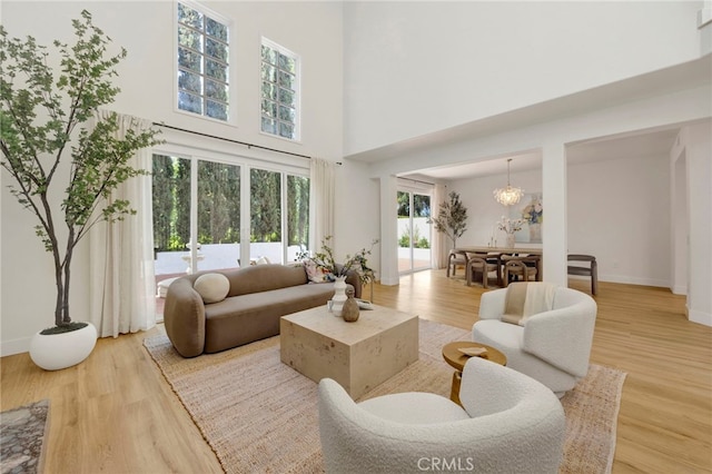 23043 Park Este, Calabasas, CA 91302 - living area featuring light wood finished floors, a towering ceiling, and a chandelier