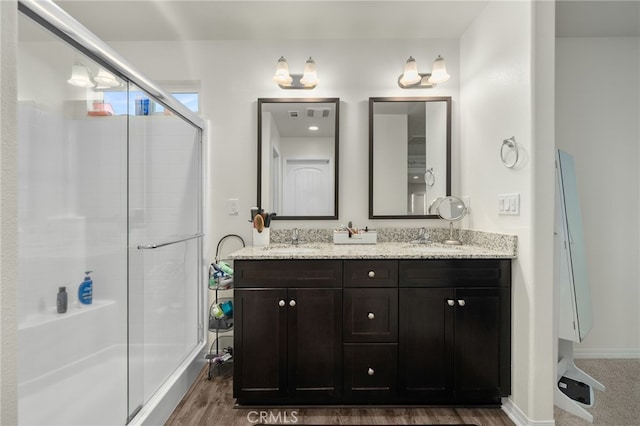 14226 Bonavento Ln, Beaumont, CA 92223 - full bathroom featuring double vanity, a shower stall, wood finished floors, and baseboards