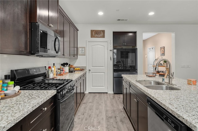 14226 Bonavento Ln, Beaumont, CA 92223 - kitchen featuring stainless steel appliances, a sink, light wood-style floors, dark brown cabinetry, and light stone counters