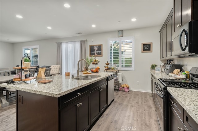14226 Bonavento Ln, Beaumont, CA 92223 - kitchen with stainless steel appliances, a sink, light wood-style flooring, baseboards, and light stone countertops