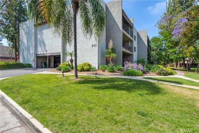 242 E Fern Ave Unit 206, Redlands, CA 92373 - view of building exterior featuring a garage and asphalt driveway