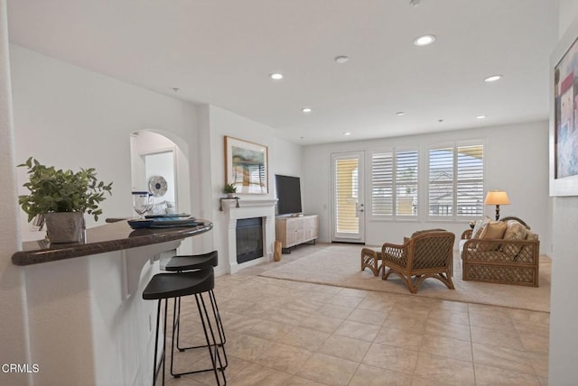 6287 Turnstone St Unit 4-304, Ventura, CA 93003 - living area with a glass covered fireplace, recessed lighting, arched walkways, and light tile patterned floors