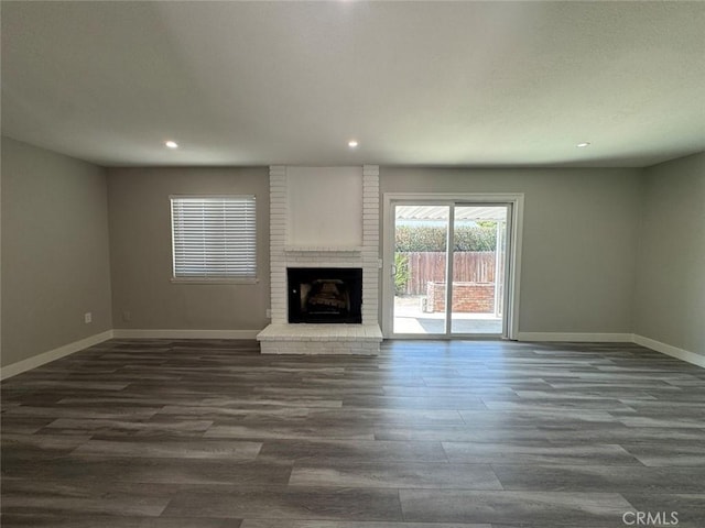 8667 Colorado Ave, Riverside, CA 92504 - unfurnished living room featuring baseboards, dark wood-type flooring, recessed lighting, and a fireplace