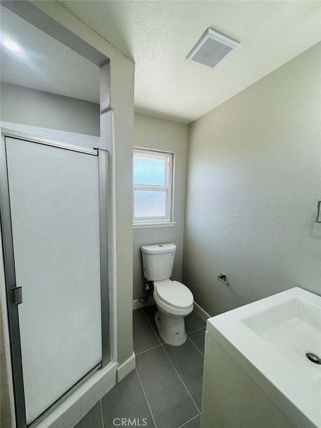 8667 Colorado Ave, Riverside, CA 92504 - bathroom featuring vanity, toilet, a shower stall, tile patterned floors, and baseboards
