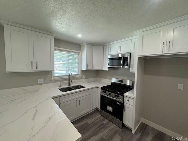 8667 Colorado Ave, Riverside, CA 92504 - kitchen with appliances with stainless steel finishes, a sink, dark wood-style flooring, white cabinets, and light stone counters