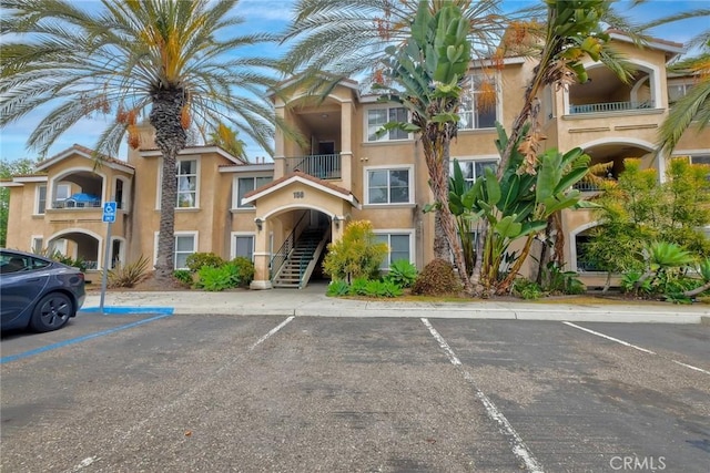 150 N River Cir Unit 306, Oceanside, CA 92057 - view of property featuring stairway and uncovered parking