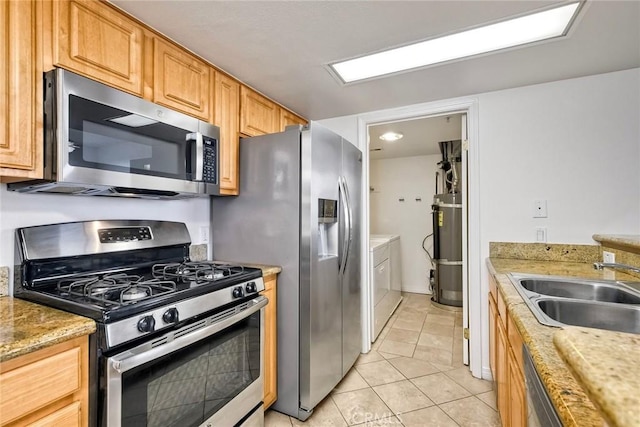 150 N River Cir Unit 306, Oceanside, CA 92057 - kitchen featuring stainless steel appliances, separate washer and dryer, a sink, light tile patterned floors, and secured water heater