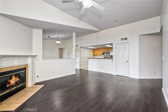 150 N River Cir Unit 306, Oceanside, CA 92057 - unfurnished living room featuring wood finished floors, ceiling fan, a fireplace, baseboards, and high vaulted ceiling