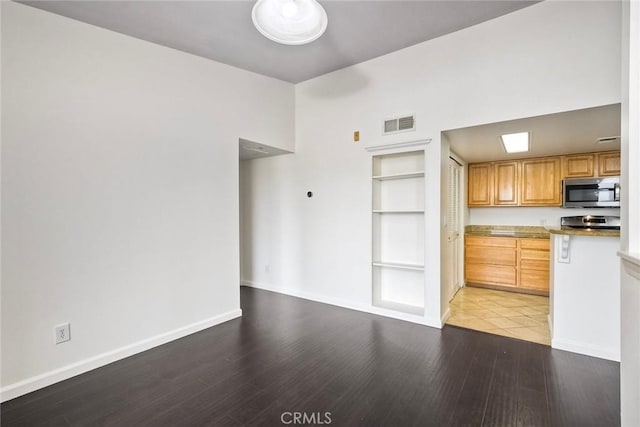 150 N River Cir Unit 306, Oceanside, CA 92057 - kitchen featuring stainless steel microwave, light wood-type flooring, baseboards, and built in shelves