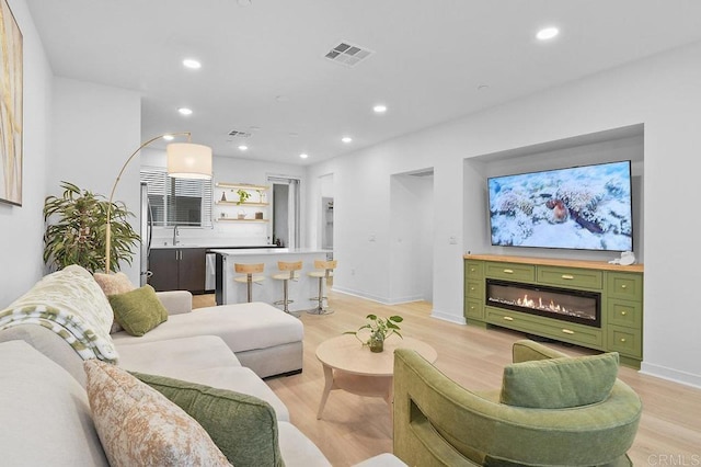 5480 Shorefront Dr # 166, San Diego, CA 92154 - living room featuring light wood-style floors, recessed lighting, a glass covered fireplace, and baseboards