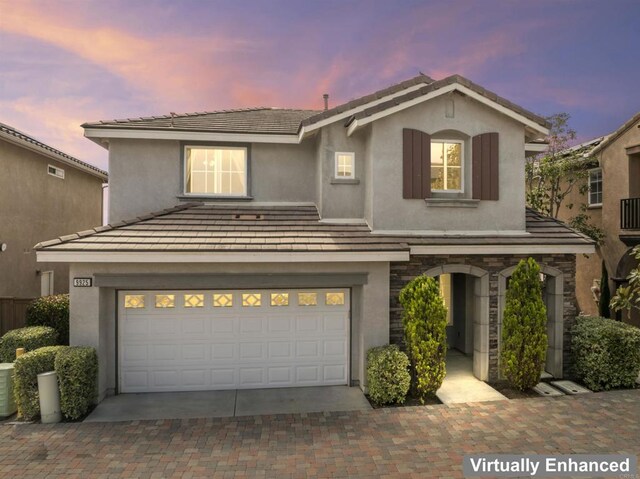 9925 Fieldthorn St, San Diego, CA 92127 - traditional-style house with stucco siding, an attached garage, decorative driveway, stone siding, and a tile roof