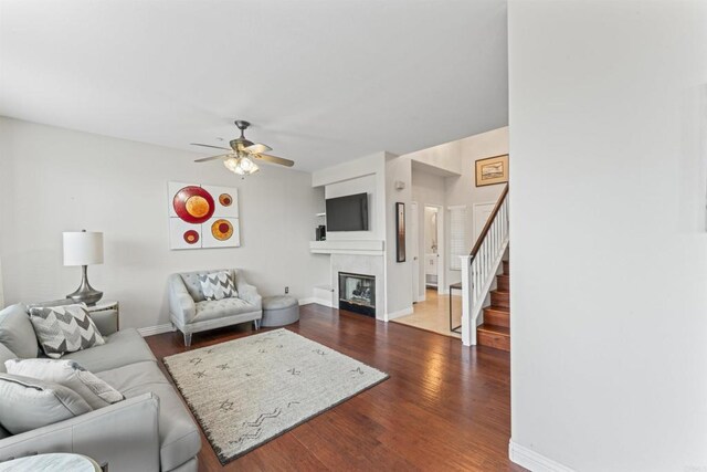 9925 Fieldthorn St, San Diego, CA 92127 - living area with stairway, a ceiling fan, dark wood-style flooring, and a glass covered fireplace