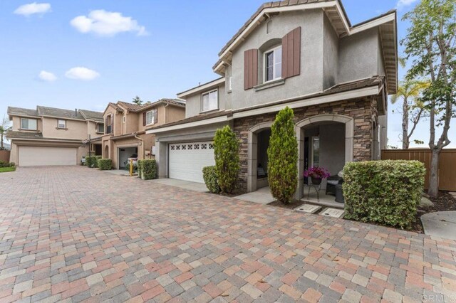 9925 Fieldthorn St, San Diego, CA 92127 - townhome / multi-family property with stucco siding, stone siding, an attached garage, and driveway