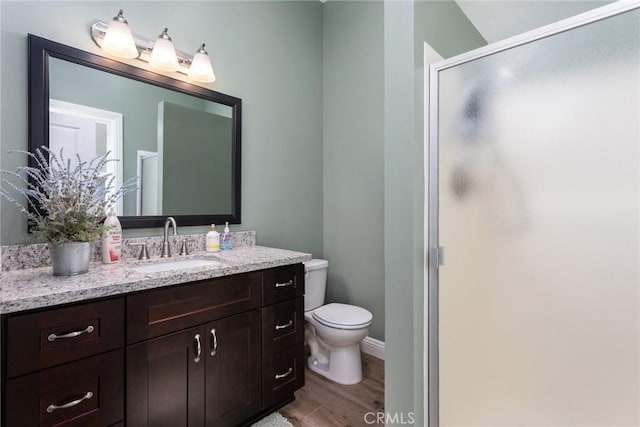 8390 Curbaril Ave, Atascadero, CA 93422 - full bath with vanity, a stall shower, toilet, wood finished floors, and baseboards