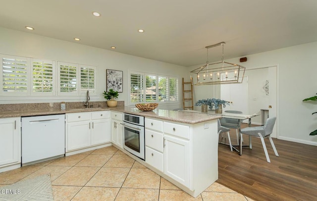 10503 Jimenez St, Sylmar, CA 91342 - kitchen with white appliances, a sink, white cabinetry, a peninsula, and recessed lighting