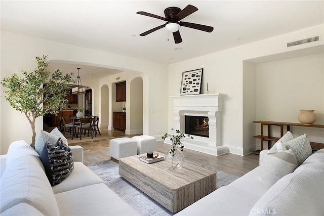 47 Via Alcamo, San Clemente, CA 92673 - living room featuring arched walkways, a ceiling fan, baseboards, and a glass covered fireplace