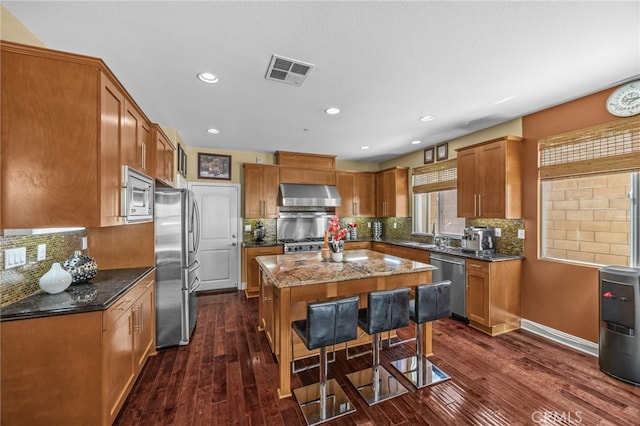 4267 Carnegie Ct, Riverside, CA 92505 - kitchen with stainless steel appliances, exhaust hood, a center island, dark wood finished floors, and recessed lighting