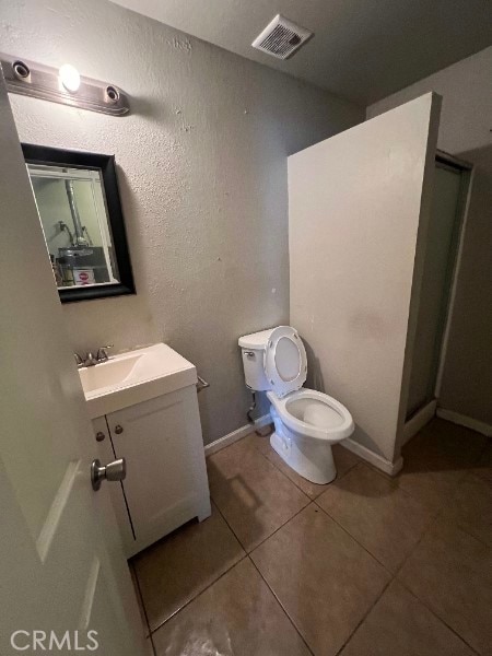 13753 Los Angeles St, Baldwin Park, CA 91706 - bathroom featuring vanity, tile patterned floors, toilet, a stall shower, and baseboards