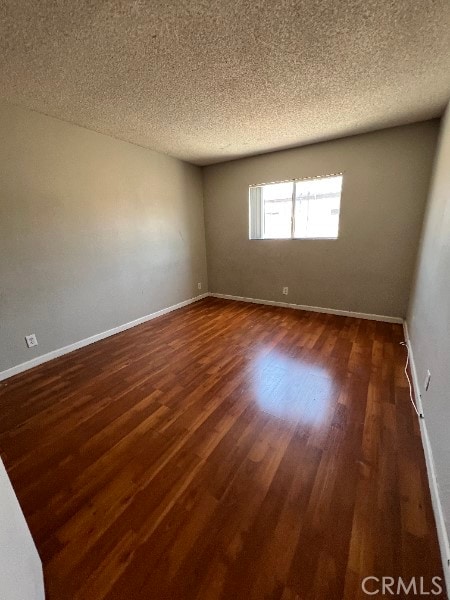 13753 Los Angeles St, Baldwin Park, CA 91706 - unfurnished room featuring dark wood-style floors, baseboards, and a textured ceiling