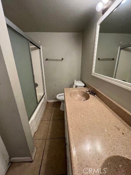 13753 Los Angeles St, Baldwin Park, CA 91706 - bathroom featuring toilet, vanity, tile patterned floors, and combined bath / shower with glass door