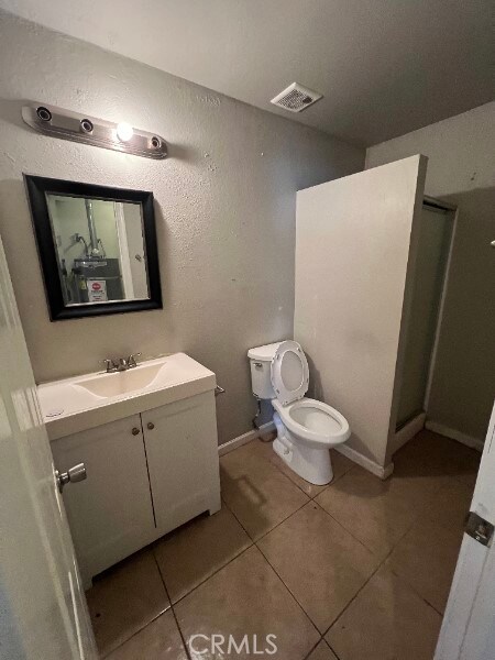 13753 Los Angeles St, Baldwin Park, CA 91706 - bathroom featuring vanity, tile patterned floors, toilet, and a walk in shower