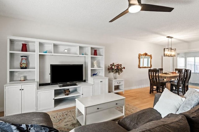 609 S Palm Ave Unit B, Hemet, CA 92543 - living room featuring a textured ceiling, ceiling fan, light wood-style floors, baseboards, and a chandelier