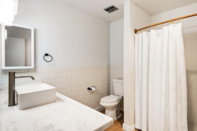 609 S Palm Ave Unit B, Hemet, CA 92543 - bathroom featuring tile walls, vanity, toilet, wainscoting, and a shower with curtain