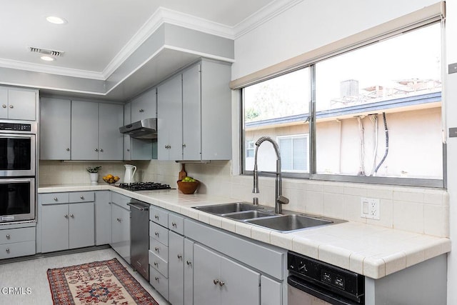 1245 S Orange Grove Blvd Unit 5, Pasadena, CA 91105 - kitchen featuring gray cabinets, appliances with stainless steel finishes, ornamental molding, decorative backsplash, and under cabinet range hood
