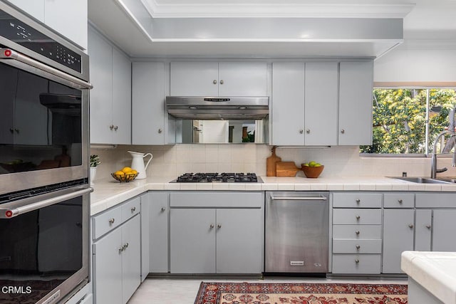 1245 S Orange Grove Blvd Unit 5, Pasadena, CA 91105 - kitchen with stainless steel double oven, ornamental molding, tasteful backsplash, and tile counters