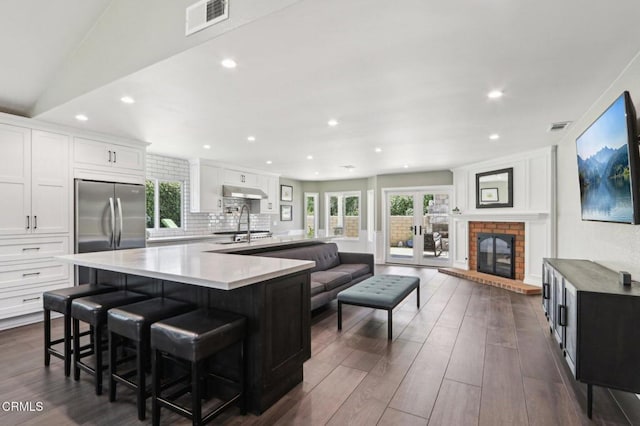 5406 Luis Dr, Agoura Hills, CA 91301 - kitchen featuring stainless steel fridge, a breakfast bar, dark wood-style floors, white cabinets, and recessed lighting