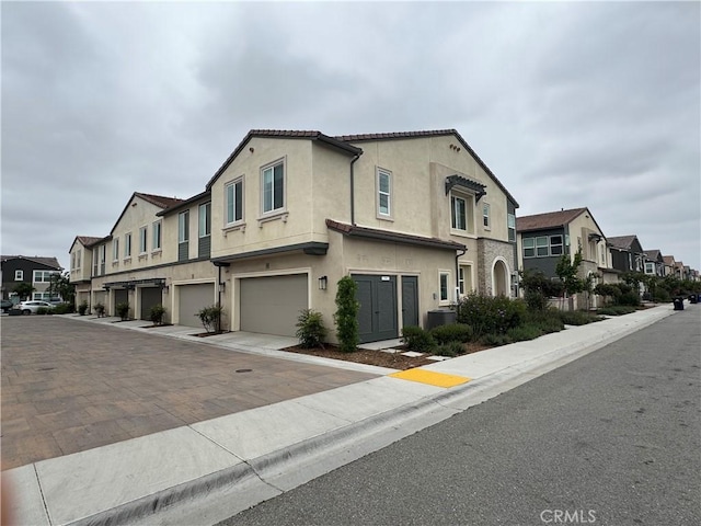 3641 E Moonlight St Unit 51, Ontario, CA 91761 - view of front facade with a residential view, a garage, stucco siding, and driveway