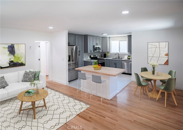1522 N Benton Way, Los Angeles, CA 90026 - kitchen with appliances with stainless steel finishes, a sink, light countertops, recessed lighting, and light wood-type flooring