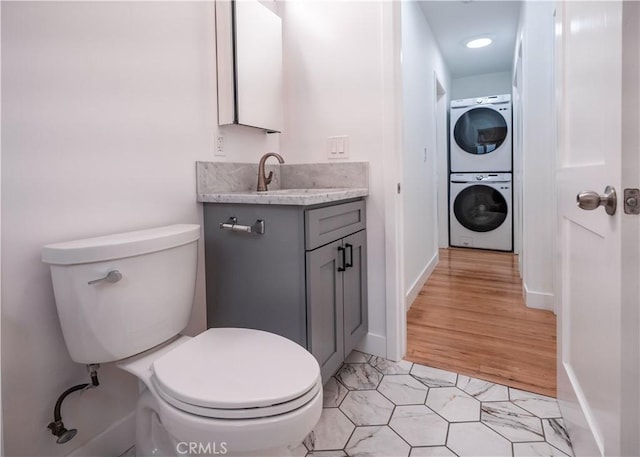 1522 N Benton Way, Los Angeles, CA 90026 - half bath with estacked washer and dryer, toilet, vanity, baseboards, and tile patterned floors