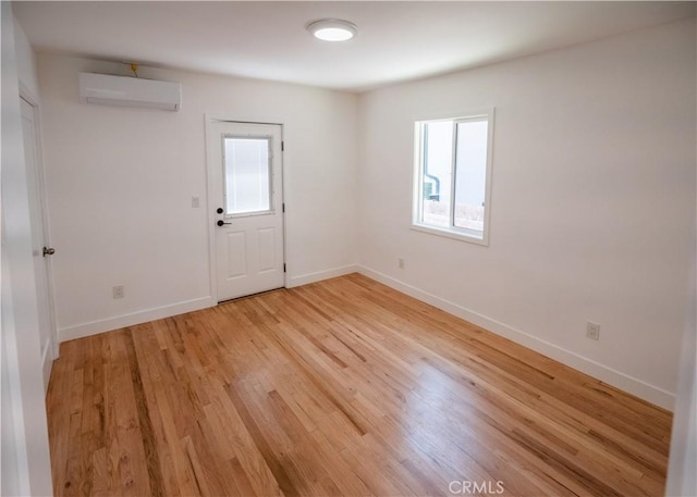 1522 N Benton Way, Los Angeles, CA 90026 - empty room featuring a wall unit AC, plenty of natural light, light wood-style flooring, and baseboards