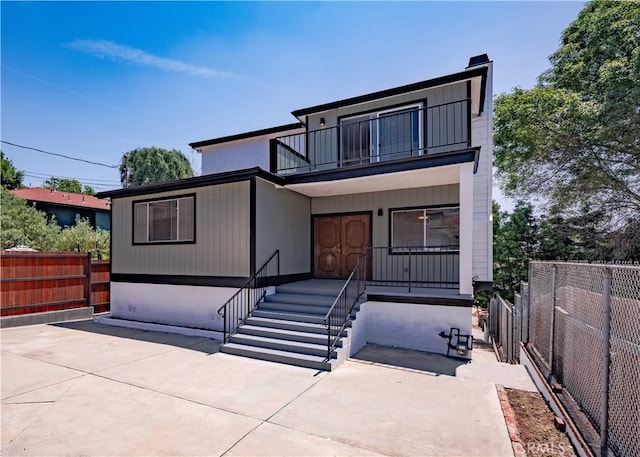 1522 N Benton Way, Los Angeles, CA 90026 - rear view of property with a balcony, covered porch, and a chimney