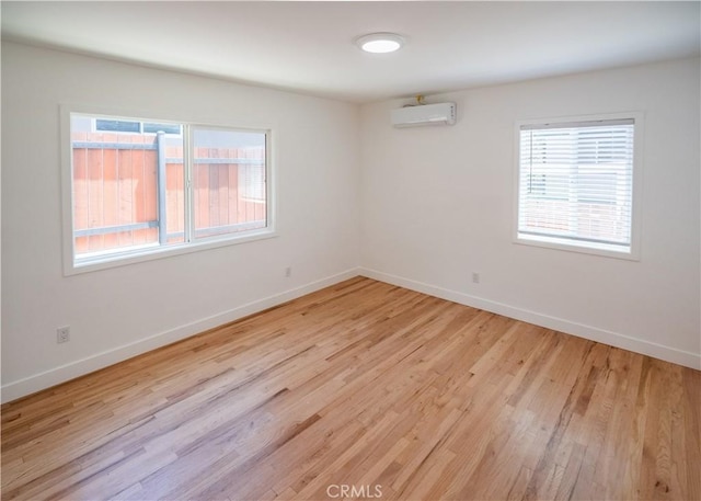 1522 N Benton Way, Los Angeles, CA 90026 - spare room featuring light wood-type flooring, a wall mounted air conditioner, and baseboards