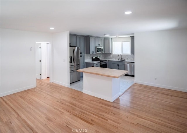 1522 N Benton Way, Los Angeles, CA 90026 - kitchen with appliances with stainless steel finishes, a sink, recessed lighting, backsplash, and light wood-style flooring