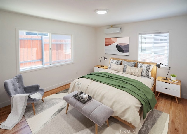 1522 N Benton Way, Los Angeles, CA 90026 - bedroom with multiple windows, a wall mounted air conditioner, wood finished floors, and baseboards